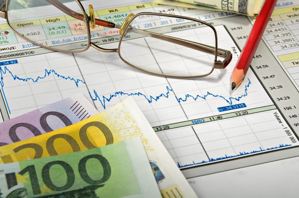 Gráfico de linha de mercado financeiro com óculos de leitura, lápis vermelho e notas de Euro, representando a análise de dados financeiros.