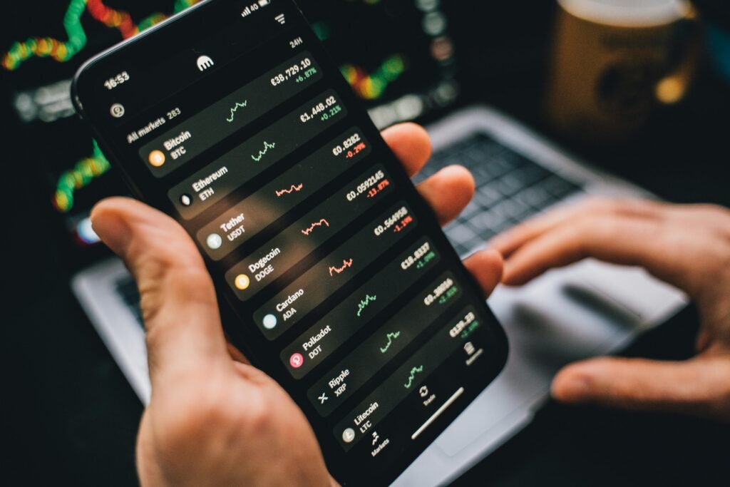 Pessoa segurando smartphone mostrando dados do mercado de criptomoedas, simbolizando ferramentas de investimento digital.