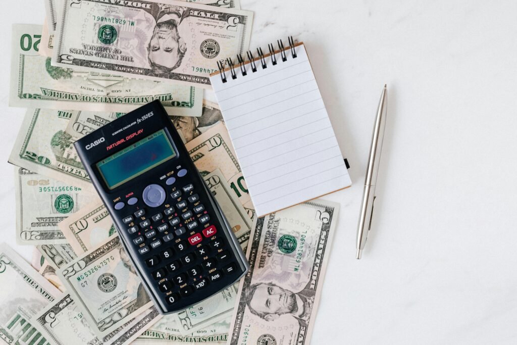 Uma mesa com dólares americanos com calculadora e caderno para calcular impostos.